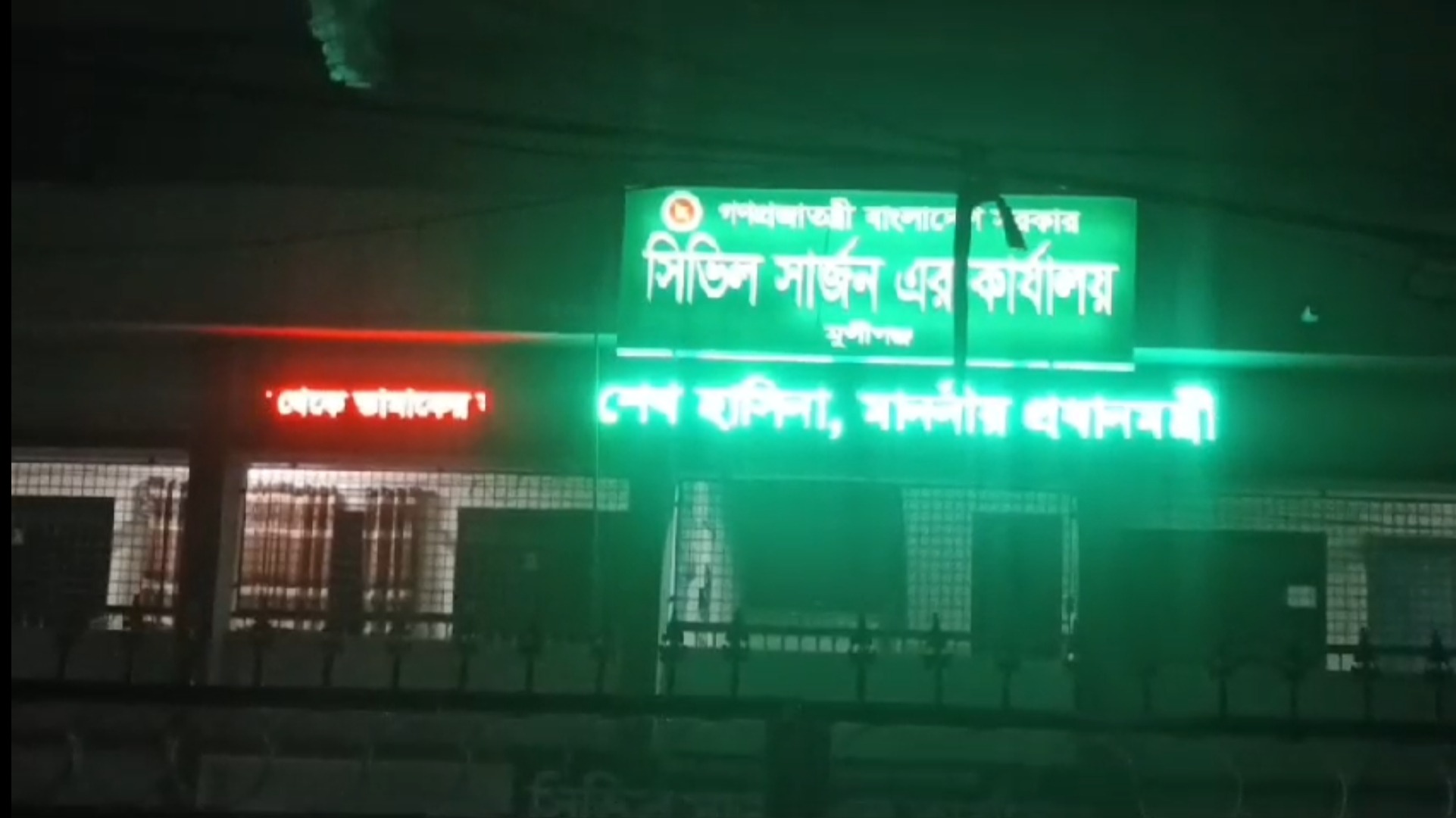 ’ক্যাপশন: মুন্সীগঞ্জ সিভিল সার্জন কার্যালয়ের প্রধান ফটকের ডিজিটাল স্ক্রিনে শেখ হাসিনাকে প্রধানমন্ত্রী উল্লেখ করা একটিশ্লোগান ভেসে ওঠে।